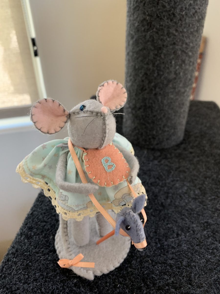 A tiny handmade baby mouse, soft and small enough to tuck into a little display or gift basket.
