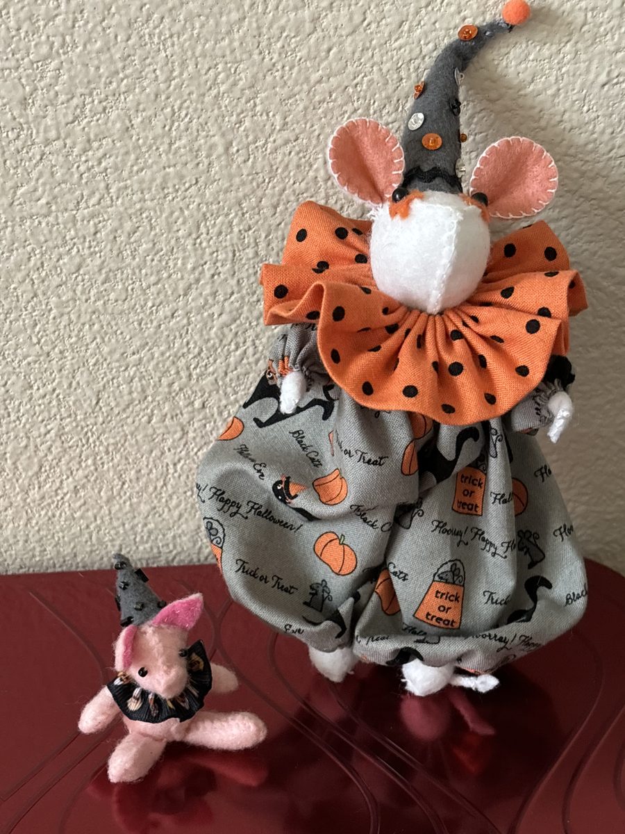 A Halloween witch-themed handmade mouse or doll with seasonal costume details